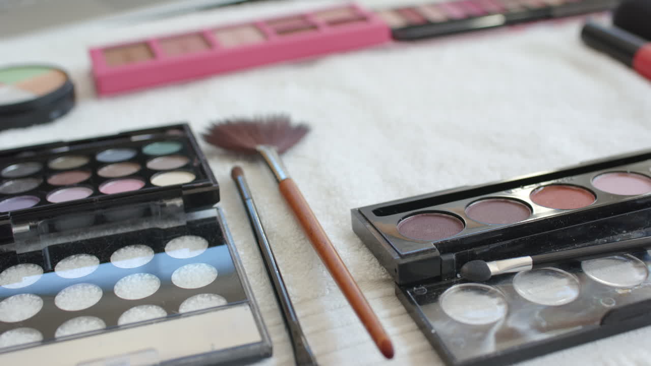 Makeup palettes and brushes arranged on table for beauty routine at home
