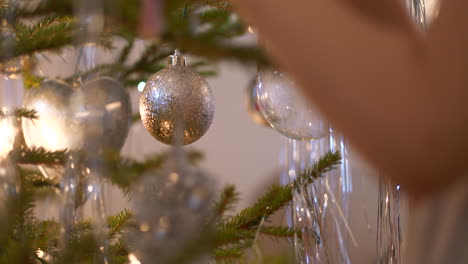 Mittlerer-Schuss-Der-Hand-Des-Jungen-Mädchens,-Die-Echten-Natürlichen-Weihnachtsbaum-Mit-Weihnachtssüßigkeiten-Schmückt