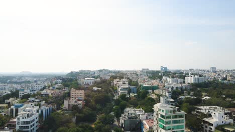 aerial drone shot following the expanse of hyderabad’s city streets, lined with skyscrapers, business districts, and residential neighborhoods.