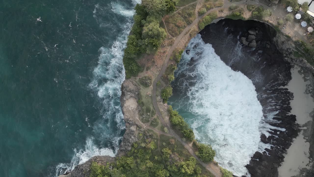 la antena gira lentamente sobre el arco de roca de la playa rota en la escarpada costa de bali