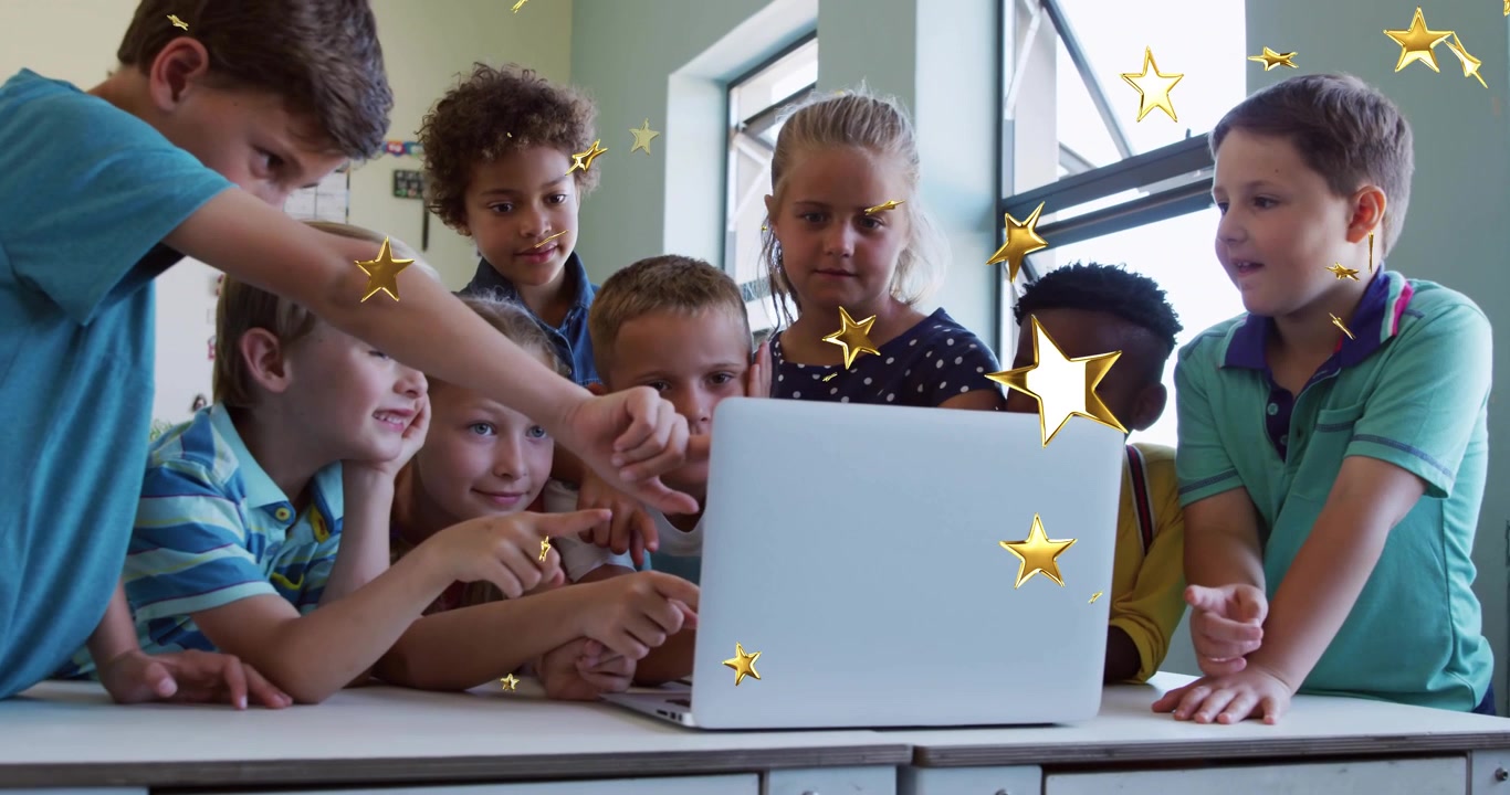 Eight students leaning over white laptop on classroom desk, boy tapping screen making golden stars