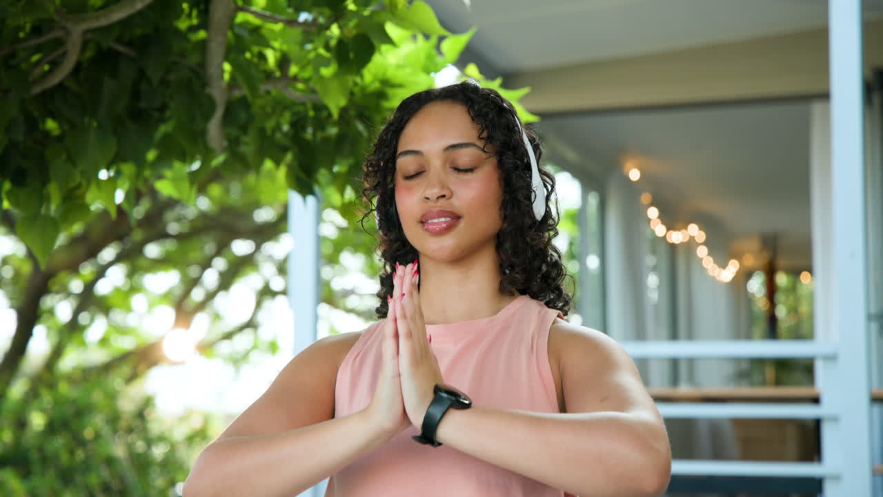 Woman meditating outdoors with headphones, enjoying peaceful moment in nature
