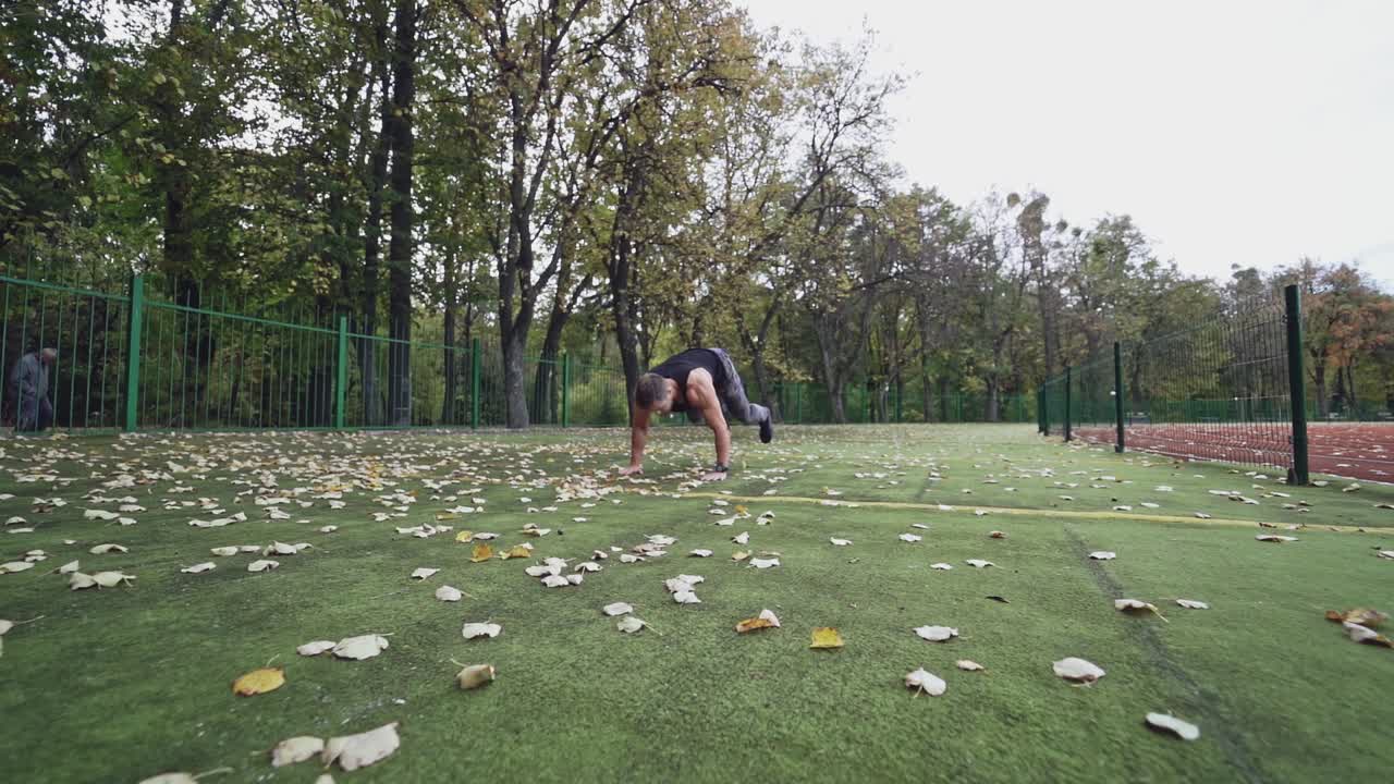 Active sportsman with muscular body outdoors. Handsome athlete doing sports among nature. Slow motion.