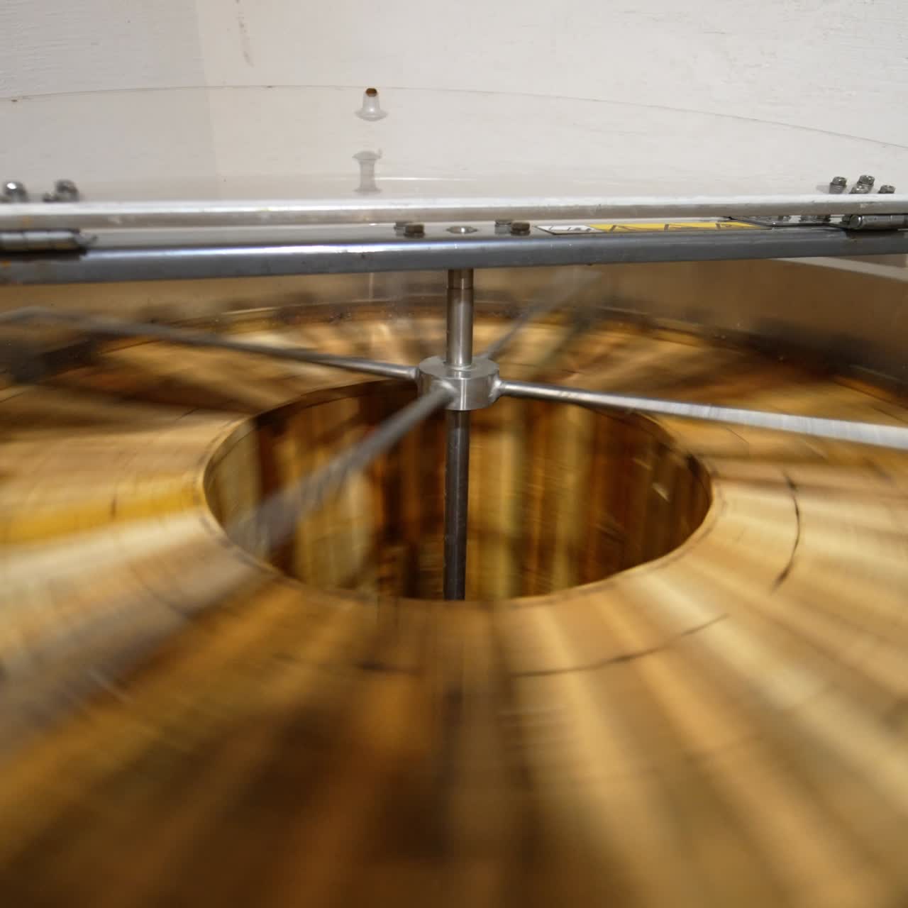 Organic honey production at bee farm. Apparatus spins the wooden frames to extract fresh healthy product from honeycombs