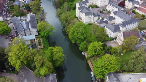 top down aerial over the river avon in bath, a variety of residential buildings and communal areas are on the riverside