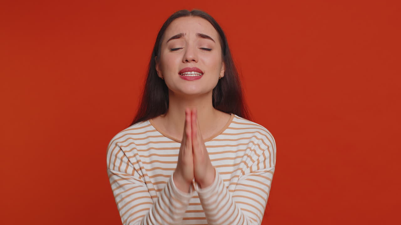 Young woman sincerely praying to God forgive me begging apology, asking for help pleading expression