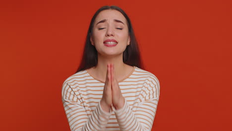 young woman sincerely praying to god forgive me begging apology, asking for help pleading expression