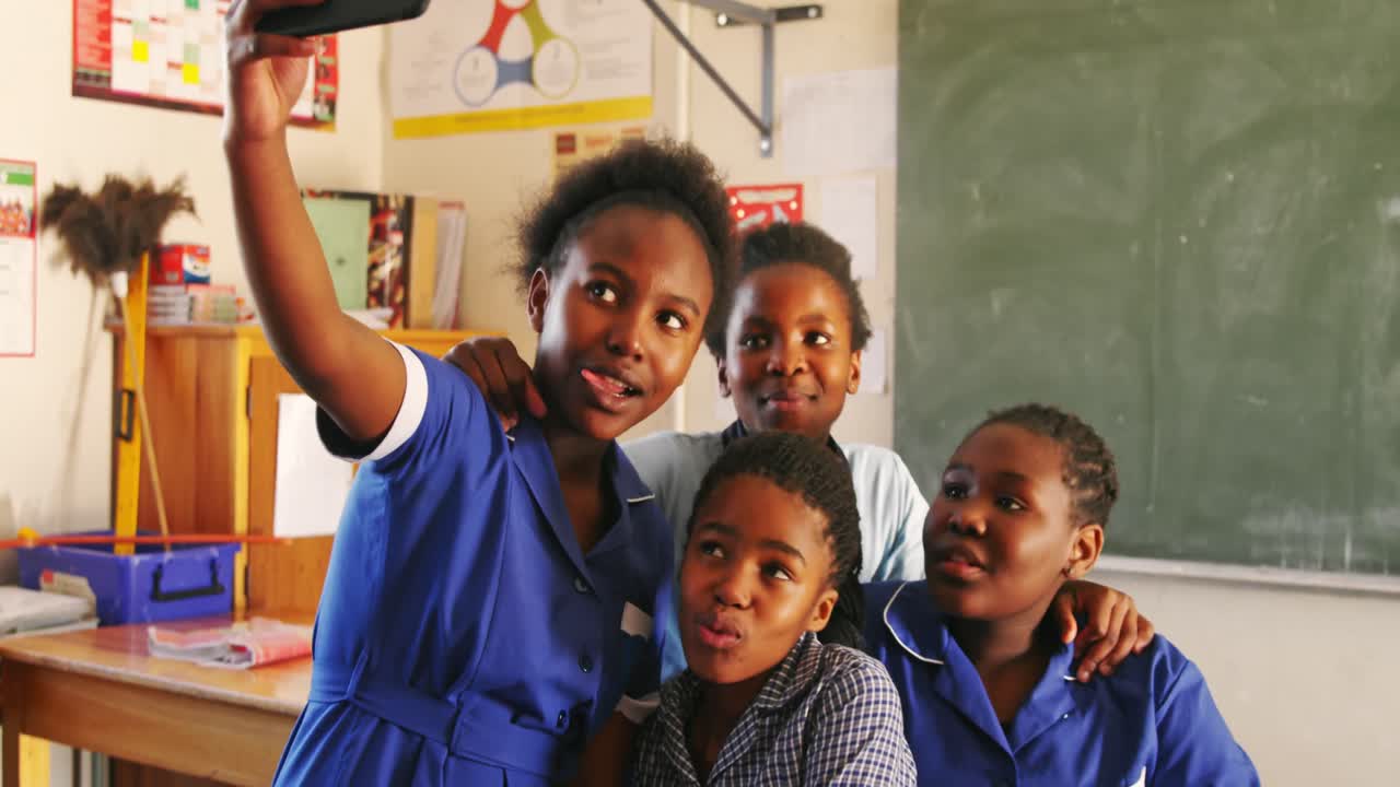 Schoolgirls taking selfies during a break at a township school 4k