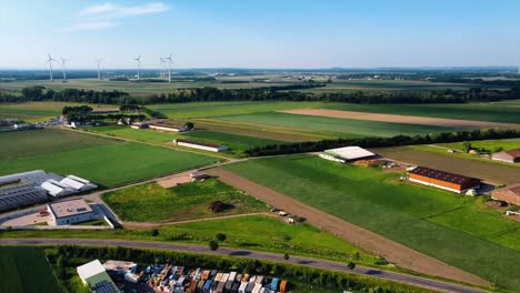 AERIAL---Agricultural-fields-and-a-wind-power-farm,-Austria,-wide-rising-shot