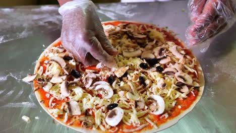 adding mushroom on top of tasty italian pizza