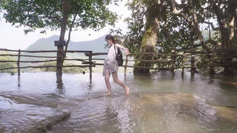 tourist woman walking in the river, slow motion