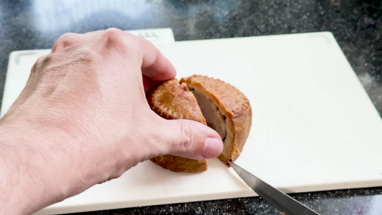 Cutting a British Pork Pie on Chopping Board – Close-Up Kitchen Food Preparation