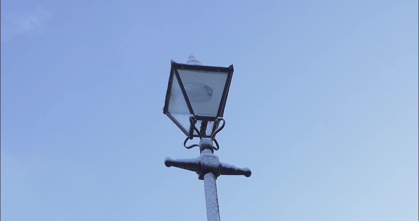 Una toma a cámara lenta de una farola cubierta de nieve.