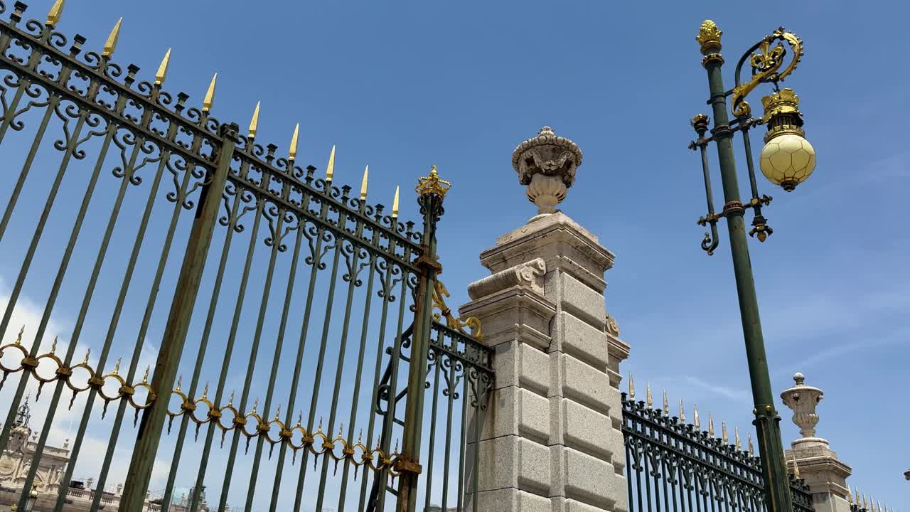 Ornate metal fence of Royal Palace, Madrid, under clear blue sky