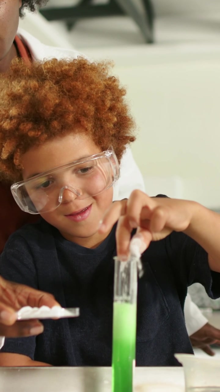 Vertical video: Dropping pill as labcoat handing tray kid with specs seeing fizz in cylinder at lab