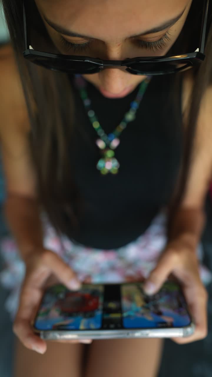 una mujer joven jugando a un juego en un teléfono inteligente