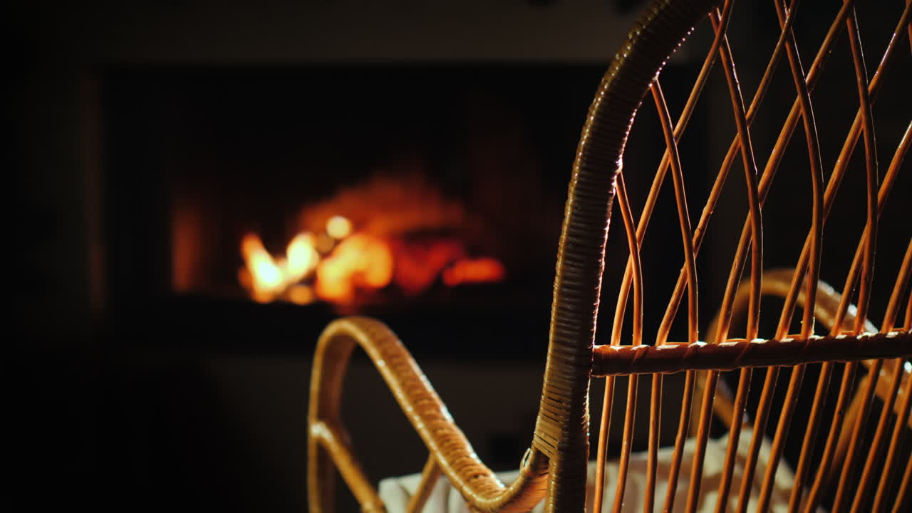 빈 흔들의자가 바느질 세트 옆 벽난로 옆에서 흔들린다