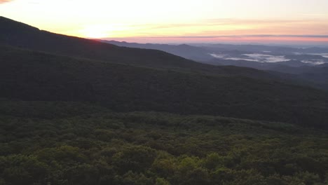 Aerial-topping-the-treetops-at-sunrise-below-grandfather-mountain-nc,-north-carolina