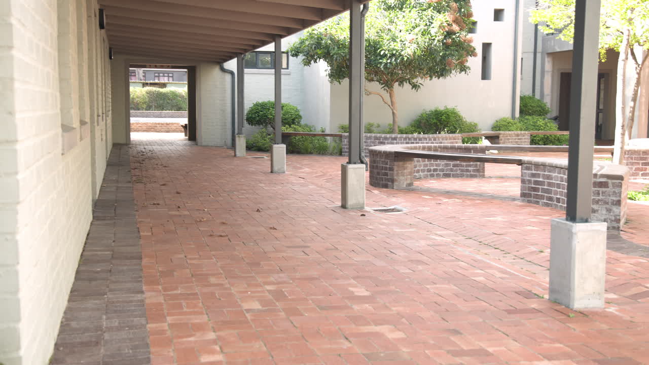 Multiracial students with backpacks running through school courtyard, excited for class