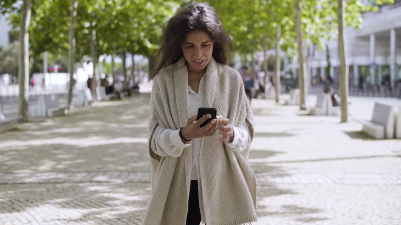Cheerful modern businesswoman using smartphone