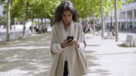 cheerful modern businesswoman using smartphone