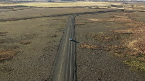 Betrunkener-Fahrer,-Der-Auf-Einer-Unbefestigten-Straße-Fährt,-Schläfriger-Fahrer,-Der-Von-Der-Straße-Abfährt,-Luftrückansicht