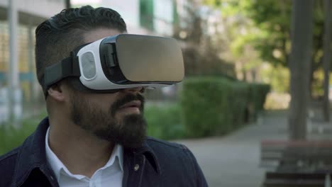 Bearded-man-using-vr-glasses-on-street