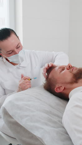 tricólogo haciendo hombre procedimiento de regeneración del cabello dermapen microneedling inyección de exosomas de vitamina