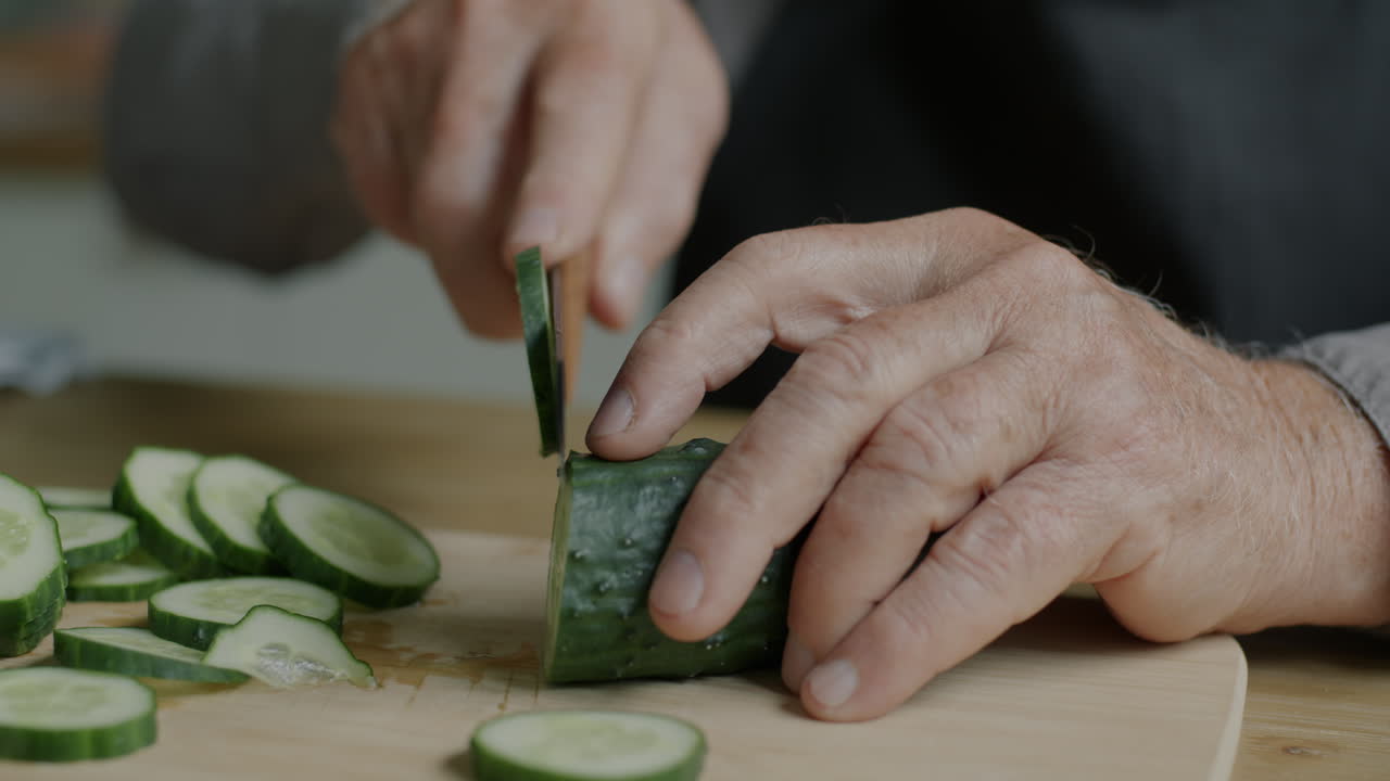 Elderly person cutting cucumbers