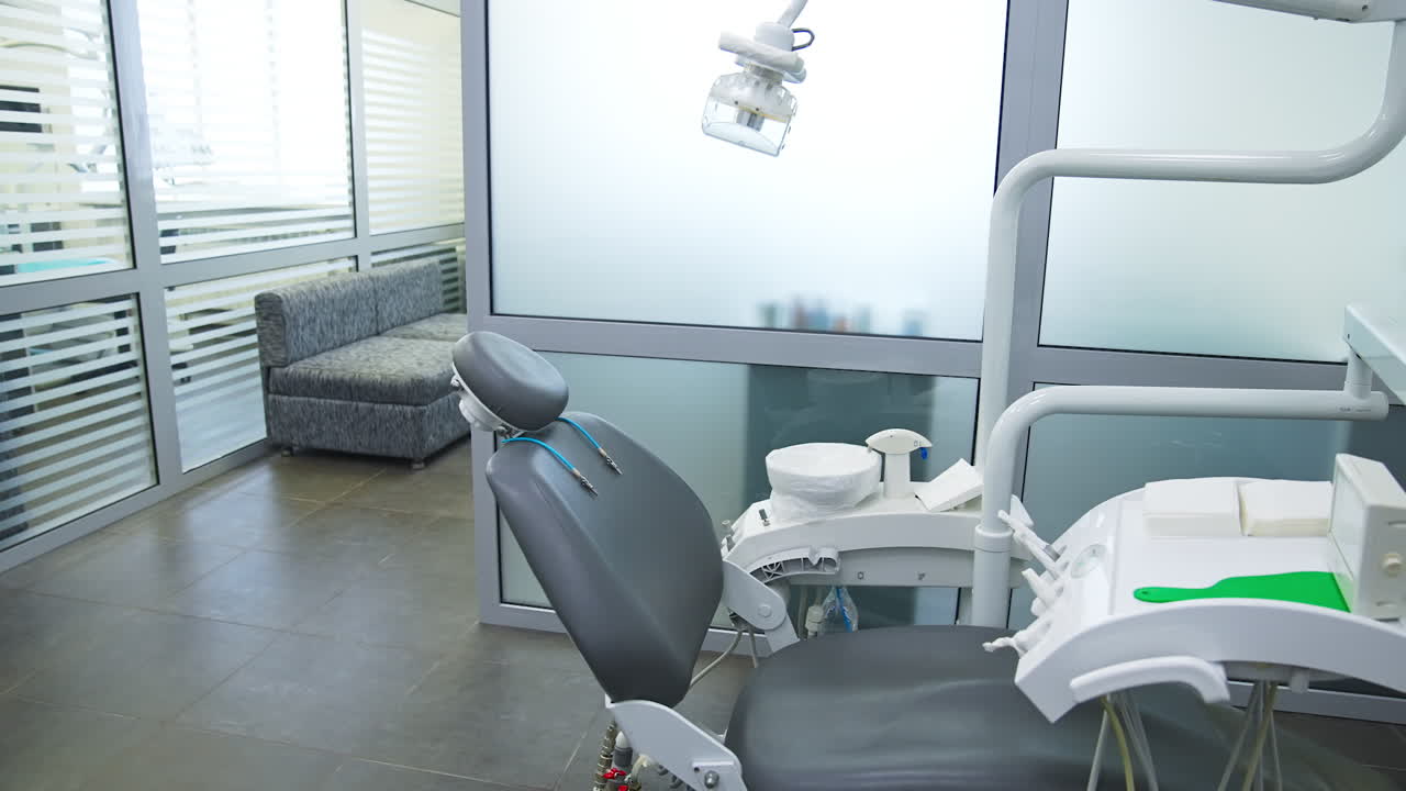 Armchair in modern dentistry clinic under the lamp. Clean and disinfected space for stomatology problems solving.