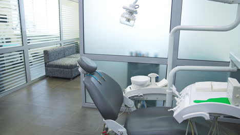 armchair in modern dentistry clinic under the lamp. clean and disinfected space for stomatology problems solving.