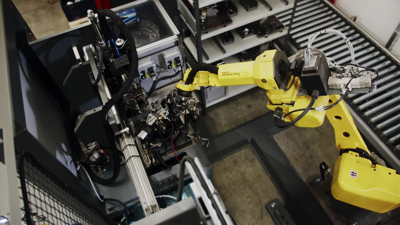 Automated robot arm moving and assembling metalic pieces in a factory