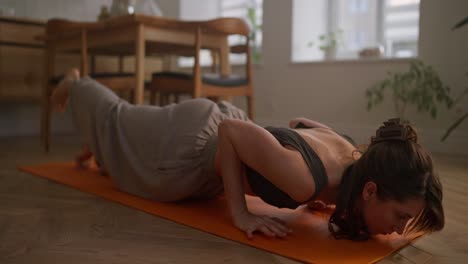 mujer practicando yoga en casa