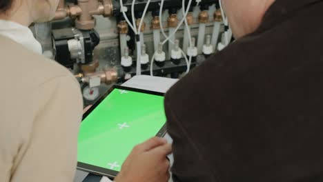 pantalla verde en la tableta de la computadora de la tableta con el hombre de negocios y la mujer de negocios