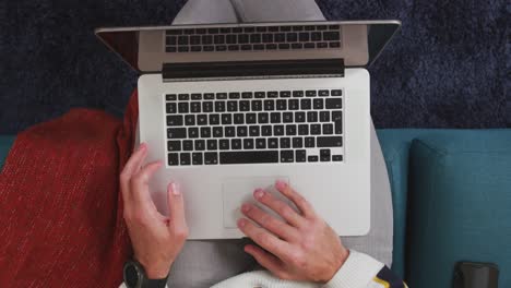 caucasian man using a laptop and his phone