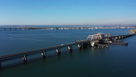 a high angle shot over elevated train tracks crossing a bay in queens, ny