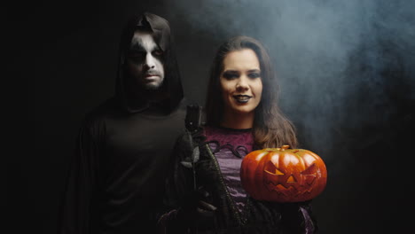 young woman dressed up like a witch next to a dark grim reaper