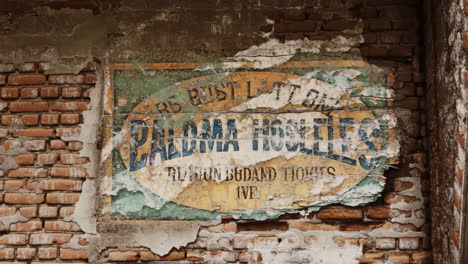old peeling sign on a brick wall