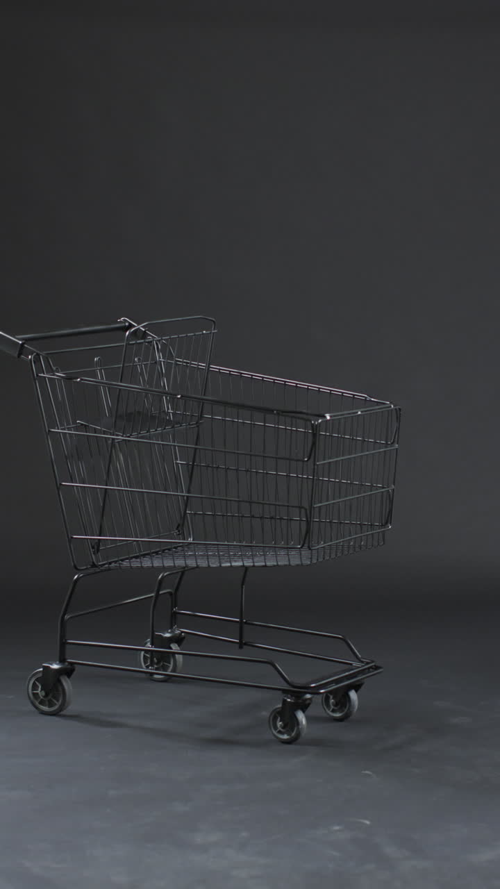 Vertical video of shopping trolley with copy space over grey background