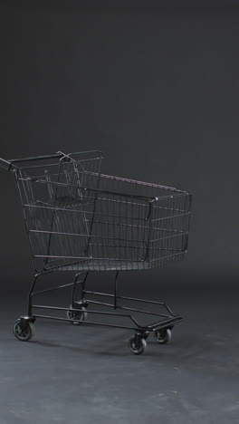 vertical video of shopping trolley with copy space over grey background