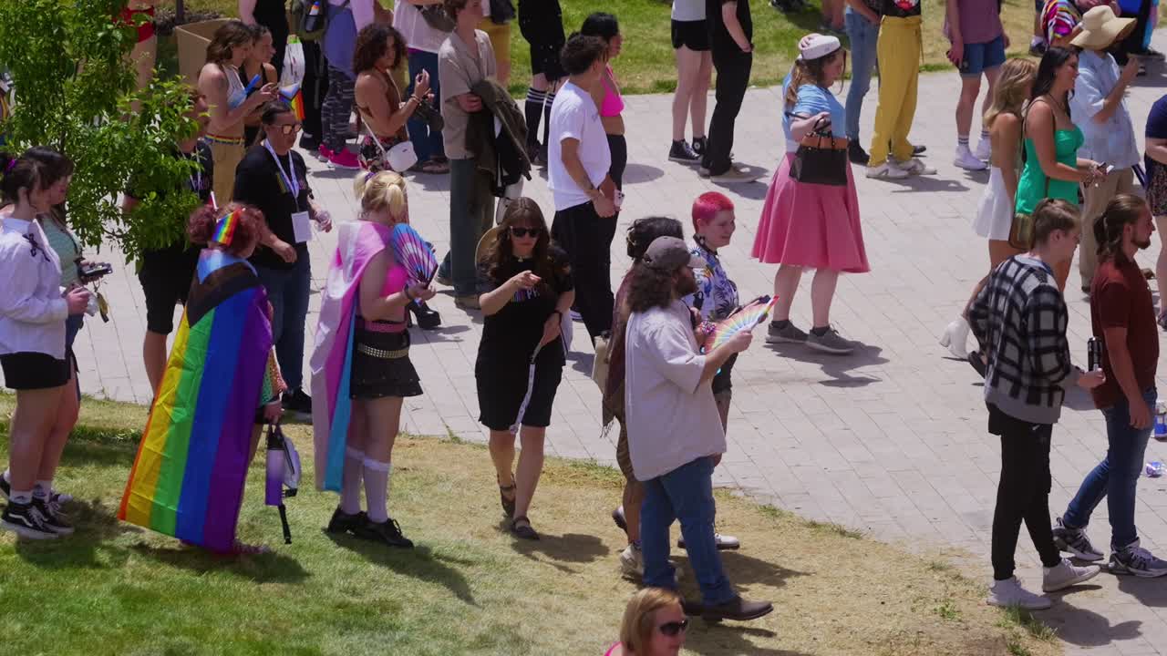 Zoomed in shot that pans to the right of crazy long line or queue of people lined up at entrance to get in and enter the gay pride parade event in Salt Lake City Library on Sunday the 2nd of June.