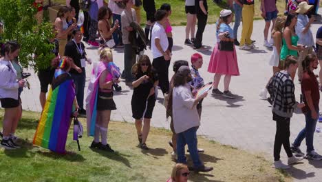 zoomed in shot that pans to the right of crazy long line or queue of people lined up at entrance to get in and enter the gay pride parade event in salt lake city library on sunday the 2nd of june.