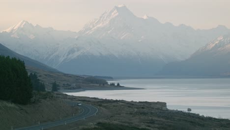 Statische-Aufnahme-Eines-Schneebedeckten-Mount-Cook-Gebirgstals-Mit-Durchfahrenden-Autos