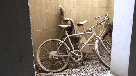 two abandoned bikes with flat tires left leaning