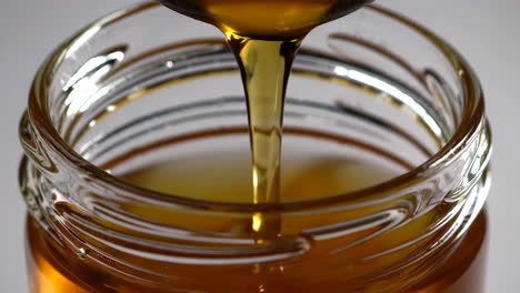 honey pouring into a jar