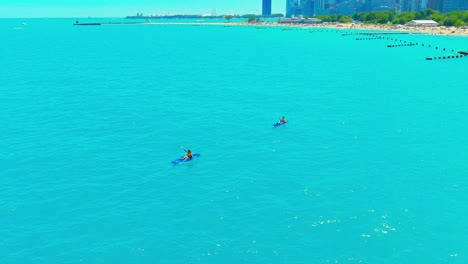 sobrevuelo aéreo de personas en kayak en la playa de la avenida norte en chicago, illinois | iluminación de la tarde