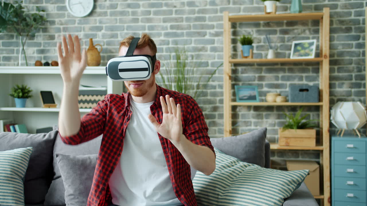 Uomo che indossa un visore VR, sperimenta la realtà virtuale su un divano