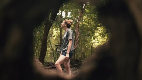 Tree-Hole-View-Of-A-Beautiful-Young-Lady-Hiking-At-Erawan-National-Park,-Thailand