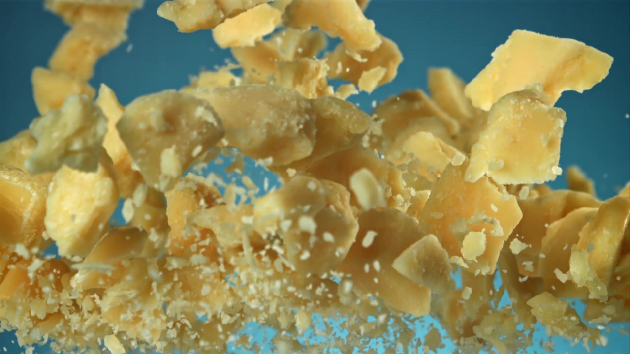 Pezzi di formaggio Parmigiano che cadono al rallentatore