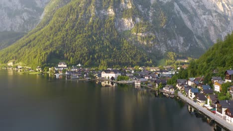 Unglaubliche-Luftaufnahme-Eines-Kleinen-Dorfes-Zwischen-Bergen-Und-Einem-See